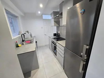 a kitchen with a stainless steel refrigerator and a sink at Room 1 Shared house 5 min from Sefton Park in Liverpool