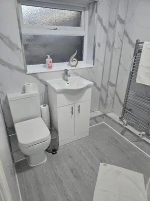 a bathroom with a toilet and a sink and a window at Room 1 Shared house 5 min from Sefton Park in Liverpool