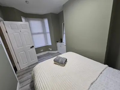 a bedroom with a white bed with a towel on it at Room 1 Shared house 5 min from Sefton Park in Liverpool