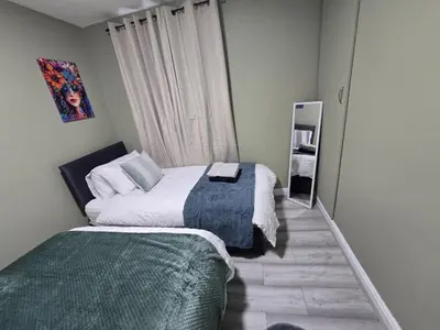 a small bedroom with two beds and a mirror at Room 2 Shared house 5 min from Sefton Park in Liverpool
