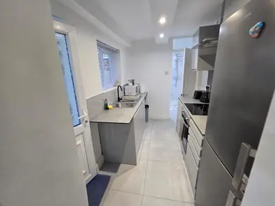a white kitchen with a sink and a counter at Room 2 Shared house 5 min from Sefton Park in Liverpool
