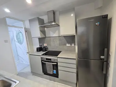 a kitchen with a stainless steel refrigerator and a sink at Room 3 Shared house 5 min from Sefton Park in Liverpool