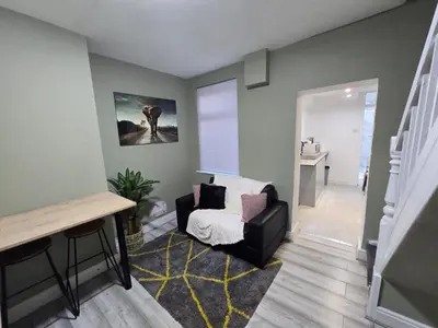 a living room with a chair and a stair case at Room 3 Shared house 5 min from Sefton Park in Liverpool