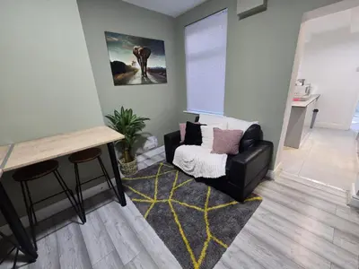a living room with a chair and a table at Room 3 Shared house 5 min from Sefton Park in Liverpool