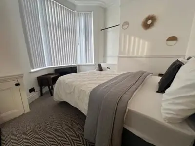 a white bedroom with a bed and a window at Liverpool Jasmine House - Spacious 2-Bed Near Anfield Stadium in Liverpool