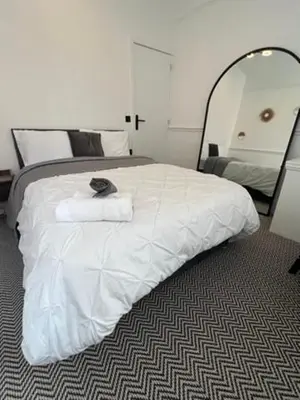 a bedroom with a white bed with a mirror at Liverpool Jasmine House - Spacious 2-Bed Near Anfield Stadium in Liverpool