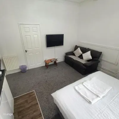 a living room with a couch and a television at Jubilee holiday flats in Blackpool