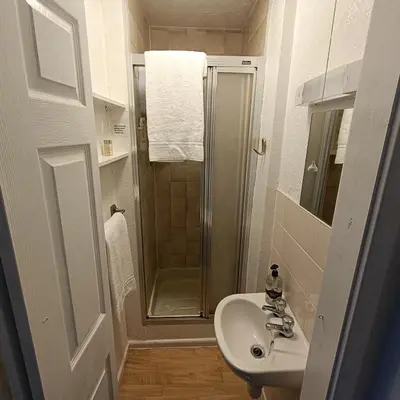 a small bathroom with a sink and a shower at Jubilee holiday flats in Blackpool