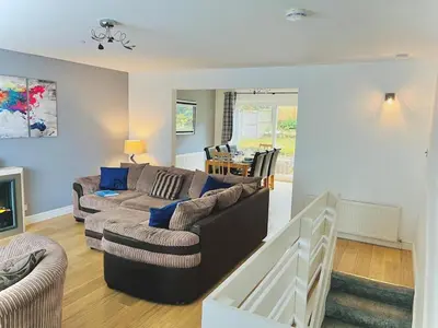 a living room with a couch and a table at Lovely 4-bed home sleeps 8 Nr Bolton Stadium & M61 in Blackrod