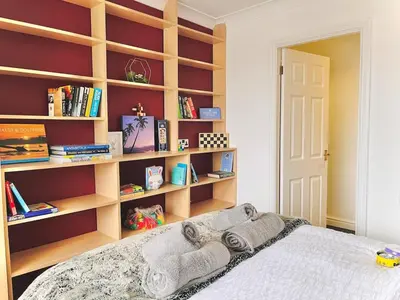 a bedroom with a bed with bookshelves at Lovely 4-bed home sleeps 8 Nr Bolton Stadium & M61 in Blackrod