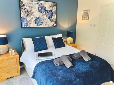 a bedroom with a bed with a laptop on it at Lovely 4-bed home sleeps 8 Nr Bolton Stadium & M61 in Blackrod