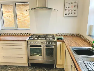 a kitchen with a stove and a sink at Lovely 4-bed home sleeps 8 Nr Bolton Stadium & M61 in Blackrod