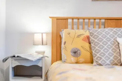 a bedroom with a bed and a nightstand with a lamp at 2 Bed in Haverigg oc-s33747 in Haverigg