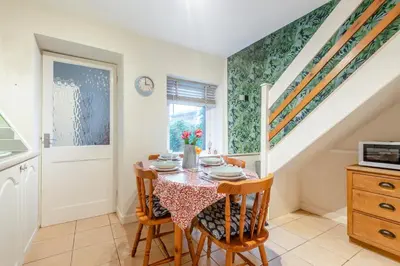 a dining room with a table and chairs and a staircase at 2 Bed in Haverigg oc-s33747 in Haverigg
