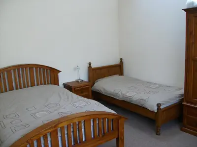 a bedroom with two beds and two night stands at Knotts Farm Holiday Cottages in Lancaster
