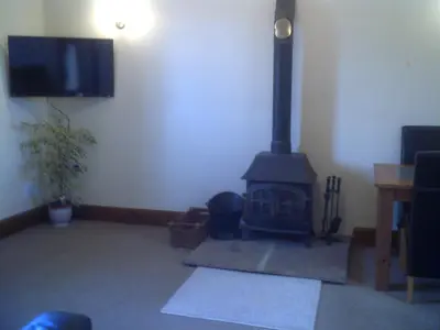 a living room with a fireplace and a flat screen tv at Knotts Farm Holiday Cottages in Lancaster