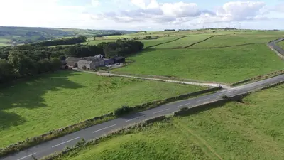 an aerial view of a house in a field with a road at Knotts Farm Holiday Cottages in Lancaster