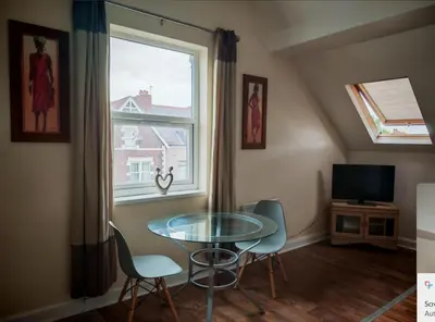 a dining room with a table and chairs and a window at MARLEY MANSIONS APARTMENT Clarendon FT3 in Wallasey