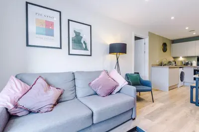 a living room with a gray couch with pink pillows at High End 2BR 2BA Parking City Access in Liverpool
