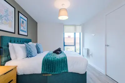 a bedroom with a large bed with blue accents at High End 2BR 2BA Parking City Access in Liverpool