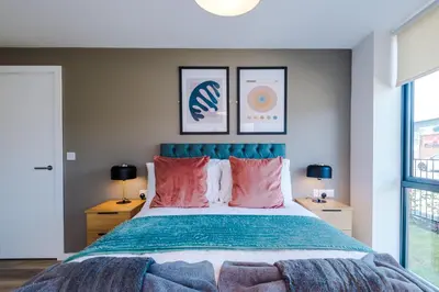 a bedroom with a large bed with pink pillows at High End 2BR 2BA Parking City Access in Liverpool