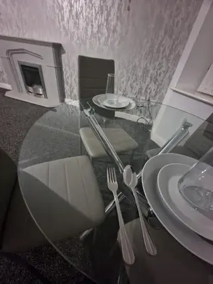 a glass table with two forks and plates on it at The Nightingale in Lower Darwen