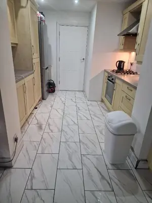 a kitchen with a white tile floor and a toilet at The Nightingale in Lower Darwen