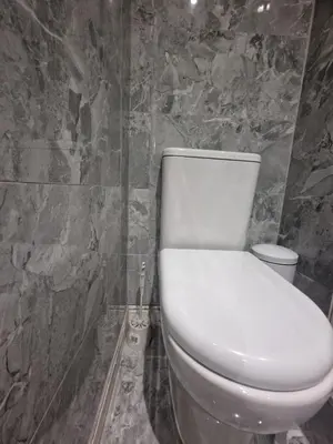 a white toilet in a bathroom with a stone wall at The Nightingale in Lower Darwen