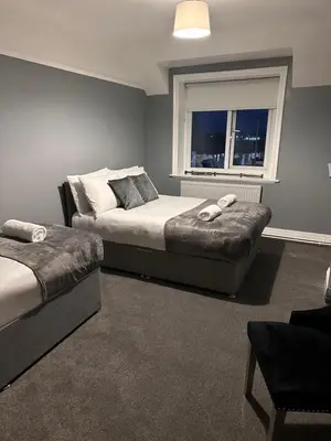 a bedroom with two beds and a window at Sheridans hotel in Wallasey