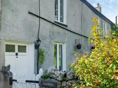 a house with a white door and some plants at Oronsay Cottage in Ulverston