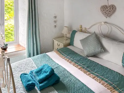 a bedroom with a bed with blue towels on it at Oronsay Cottage in Ulverston