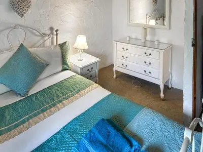 a bedroom with a bed and a dresser with a mirror at Oronsay Cottage in Ulverston