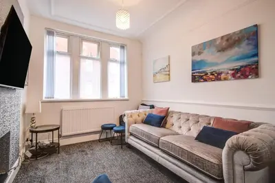 a living room with a couch and a tv at Beach Meets City - Two Bed Stay Near to Liverpool in Wallasey