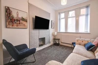 a living room with a couch and a fireplace at Beach Meets City - Two Bed Stay Near to Liverpool in Wallasey