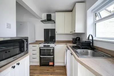 a kitchen with white cabinets and a sink at Beach Meets City - Two Bed Stay Near to Liverpool in Wallasey