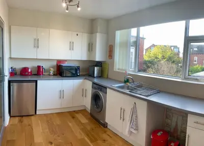 a kitchen with a sink and a washing machine at Southport-Birkdale Luxury Haven in Southport
