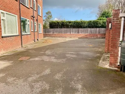 an empty parking lot next to a brick building at Southport-Birkdale Luxury Haven in Southport