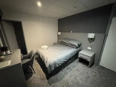 a small bedroom with a bed and a chair at Waverley Beach Hotel in Blackpool