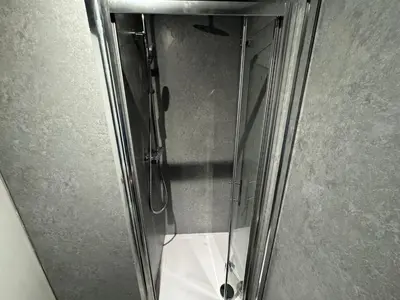 a glass shower door with a reflection of a toilet at Waverley Beach Hotel in Blackpool