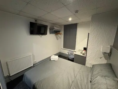 a room with a bed and a tv on the wall at Waverley Beach Hotel in Blackpool