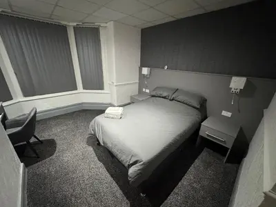 a bedroom with a bed and a desk and a chair at Waverley Beach Hotel in Blackpool