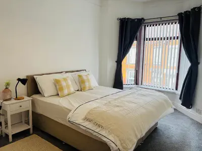 a bedroom with a bed and a large window at Wallasey Nest in Wallasey