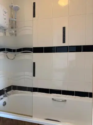 a bath tub in a bathroom with a glass wall at Wallasey Nest in Wallasey