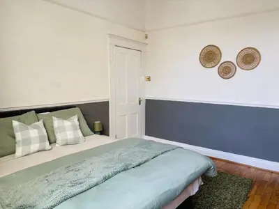 a bedroom with a bed and two mirrors on the wall at Wallasey Nest in Wallasey
