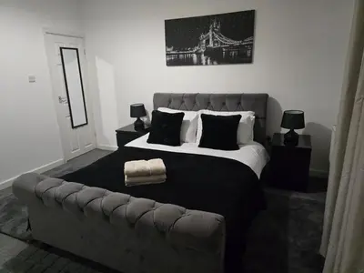 a bedroom with a large bed and a couch at Room 1 Shared House 3 min from Stadium in Liverpool