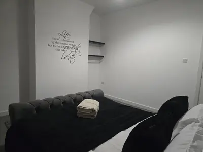 a black bed in a room with a sign on the wall at Room 1 Shared House 3 min from Stadium in Liverpool