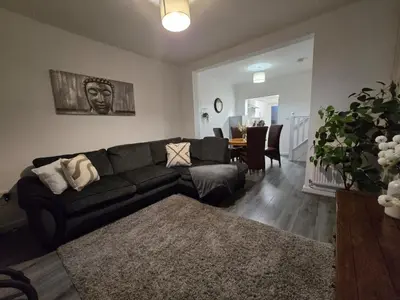 a living room with a black couch and a table at Room 2 Shared House 3 min from Stadium in Liverpool