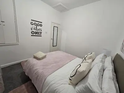 a white bedroom with a bed with pillows on it at Room 2 Shared House 3 min from Stadium in Liverpool
