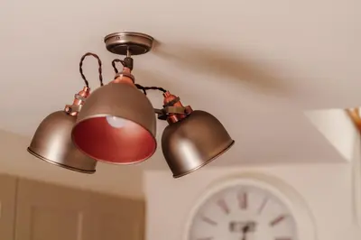 two lights hanging from a ceiling with a clock at Ellenboro House, Cosy Sleeps 2, Near Cartmel in Grange Over Sands