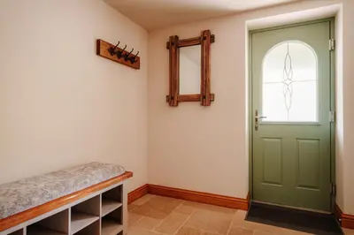 a hallway with a green door and a window at Ellenboro House, Cosy Sleeps 2, Near Cartmel in Grange Over Sands